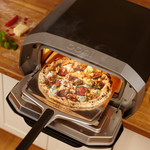 pizza being removed from the Ooni Volt 12 Electric pizza oven